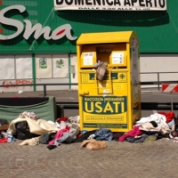 Foto Nicoloro G. Scatti fotografici effettuati qua e là cogliendo al volo persone, animali, particolari, effetti, curiosità. nella foto Un cassone per la raccolta di abiti usati saccheggiato da ignoti.