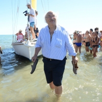 Foto Nicoloro G. 15/08/2016 Cervia ( Ravenna ) Ventiquattresima edizione di ' Cervia, la spiaggia ama il libro ', manifestazione che culmina il giorno di Ferragosto con il tradizionale sbarco degli scrittori sulla spiaggia a bordo di antiche imbarcazioni. nella foto lo scrittore Salvatore Giannella appena sbarcato.