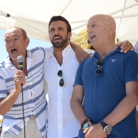Foto Nicoloro G. 15/08/2016 Cervia ( Ravenna ) Ventiquattresima edizione di ' Cervia, la spiaggia ama il libro ', manifestazione che culmina il giorno di Ferragosto con il tradizionale sbarco degli scrittori sulla spiaggia a bordo di antiche imbarcazioni. nella foto da sinistra Raoul Casadei, il sindaco di Cervia Luca Coffari e il comico Maurizio Ferrini mentre intonano una canzone romagnola.