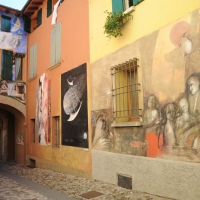 Foto Nicoloro G. 15/09/2011 Dozza ( Bologna ) Ventitreesima edizione della Biennale del Muro Dipinto, manifestazione di arte contemporanea che vede impegnati alcuni artisti scelti tra numerosi che propongono bozzetti per ornare le facciate delle case del borgo medievale in provincia di Bologna. Iniziativa nata nel 1960 e che vede il contributo del Museo d’ Arte Moderna di Bologna. nella foto Dipinti di passate edizioni