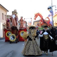 Foto Nicoloro G. 10/02/2013 Cento ( Ferrara ) E' partita l' edizione 2013 del " Cento Carnevale d' Europa " che si svolgerà nei giorni 10 - 17 - 24 febbraio e 3 marzo nonostante il sisma che ha colpito duramente la cittadina di Cento. Il Carnevale di Cento è l' unico ad essere gemellato con lo storico Carnevale di Rio de Janeiro. nella foto Figuranti in costume e un carro sullo sfondo  