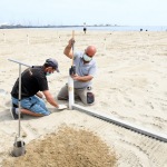 Foto Nicoloro G.   19-05-2020   Marina di Ravenna   Con l\' imminente riapertura degli stabilimenti balneari i gestori dei bagni si apprestano a metterli in sicurezza e a norma. nella foto operazioni di posizionamento dei paletti per gli ombrelloni con misurazione di distanza e allineamento.