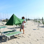 Foto Nicoloro G.   23-05-2020   Cervia (Ravenna)   La regione Emilia-Romagna ha anticipato di due giorni l\' apertura della stagione balneare. Tuttavia pochissimi sono gli stabilimenti pronti a cominciare, mentre la maggior parte e\' ancora indietro con i preparativi, come dimostrano chilometri di litorale vuoti in corrispondenza degli stabilimenti balneari. nella foto il titolare del Bagno Sorriso apre alle 8 di mattina quello che, molto probabilmente, e\' il primo ombrellone della stagione, per una famiglia di Bologna.