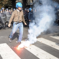 Foto Nicoloro G. 14/10/2011 Milano Manifestazione con corteo dei collettivi studenteschi al grido ” Salviamo la scuola no le banche “.  nella foto Le forze dell'ordine sono oggetto di lancio di uova, frutta, verdura e candelotti fumogeni