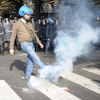 Foto Nicoloro G. 14/10/2011 Milano Manifestazione con corteo dei collettivi studenteschi al grido ” Salviamo la scuola no le banche “.  nella foto Le forze dell'ordine sono oggetto di lancio di uova, frutta, verdura e candelotti fumogeni
